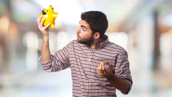 man looking inside a piggy bank