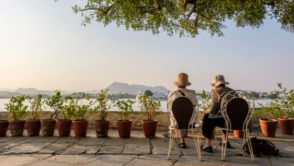 Couple sitting in front of a lake enjoying the view after their retirement